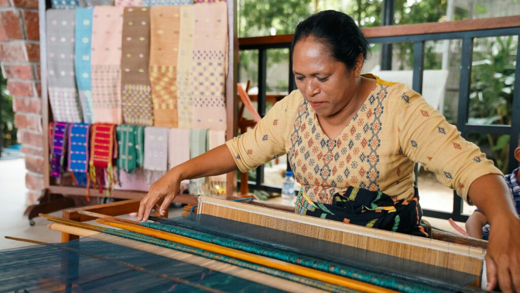 Lao woman weaving silk fabric on traditional wooden loom