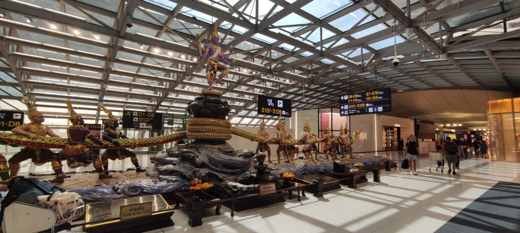 Arrival hall inside Thailand airport with travelers and immigration counters for Thailand Digital Arrival Card processing