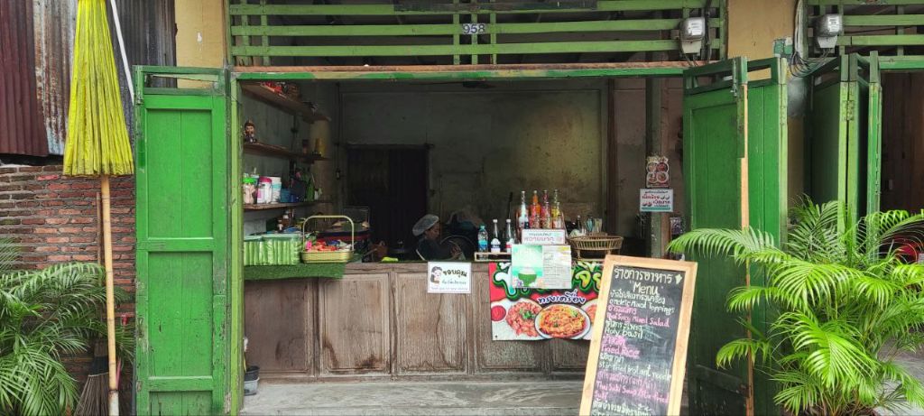 Smoothie bar in Talat Noi Bangkok with green wooden door and friendly local vendors
